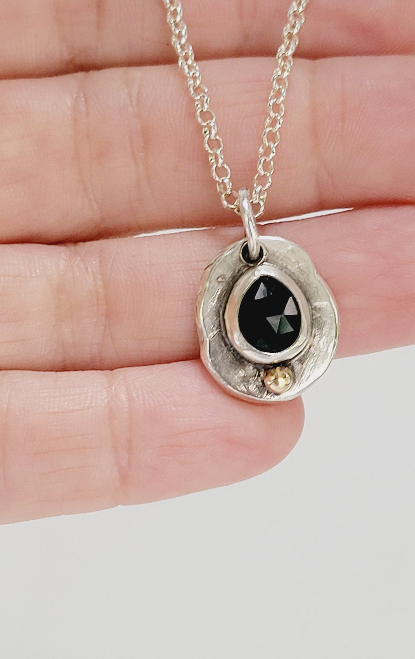 Handmade pendant in sterling silver with 14k gold detail and faceted onyx set