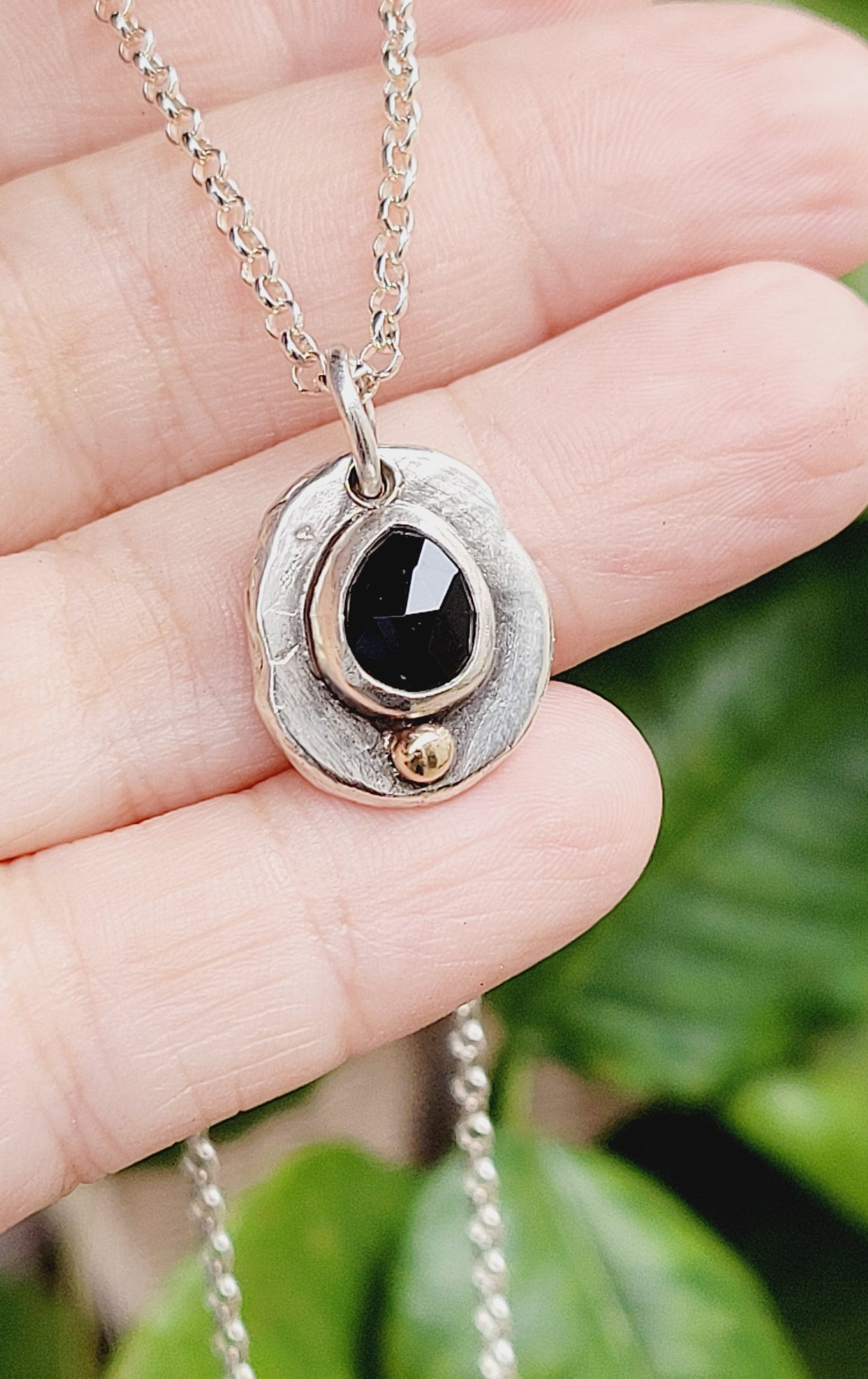 Handmade pendant in sterling silver with 14k gold detail and faceted onyx set
