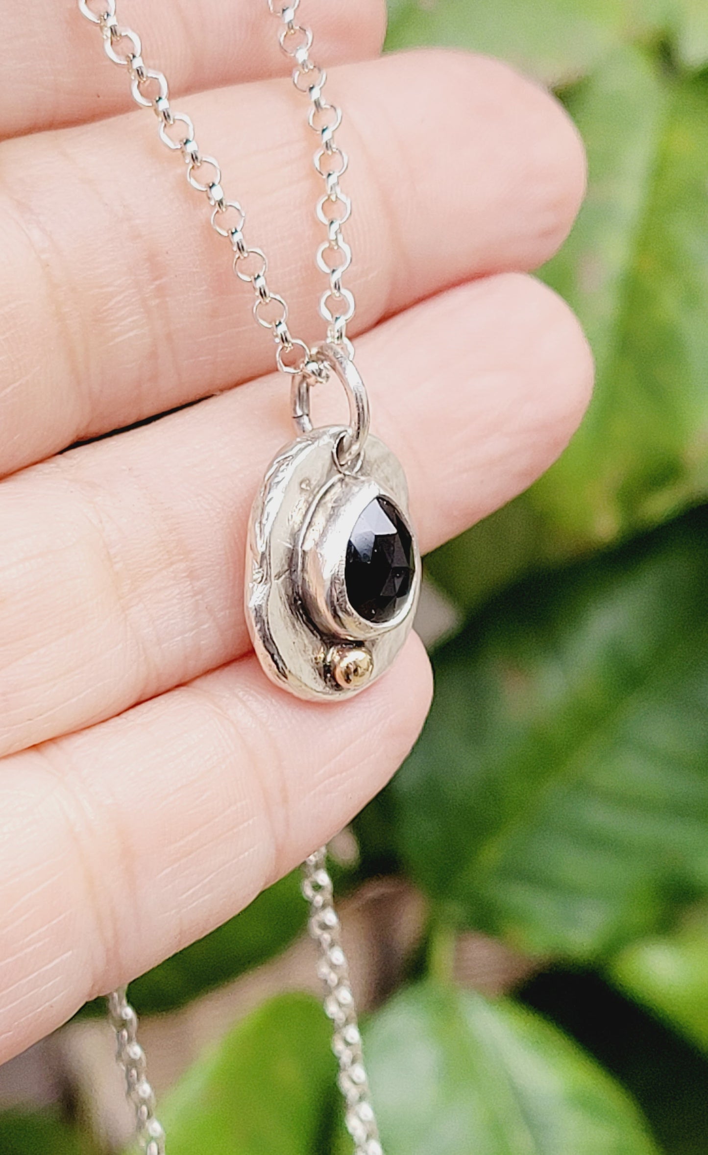 Handmade pendant in sterling silver with 14k gold detail and faceted onyx set