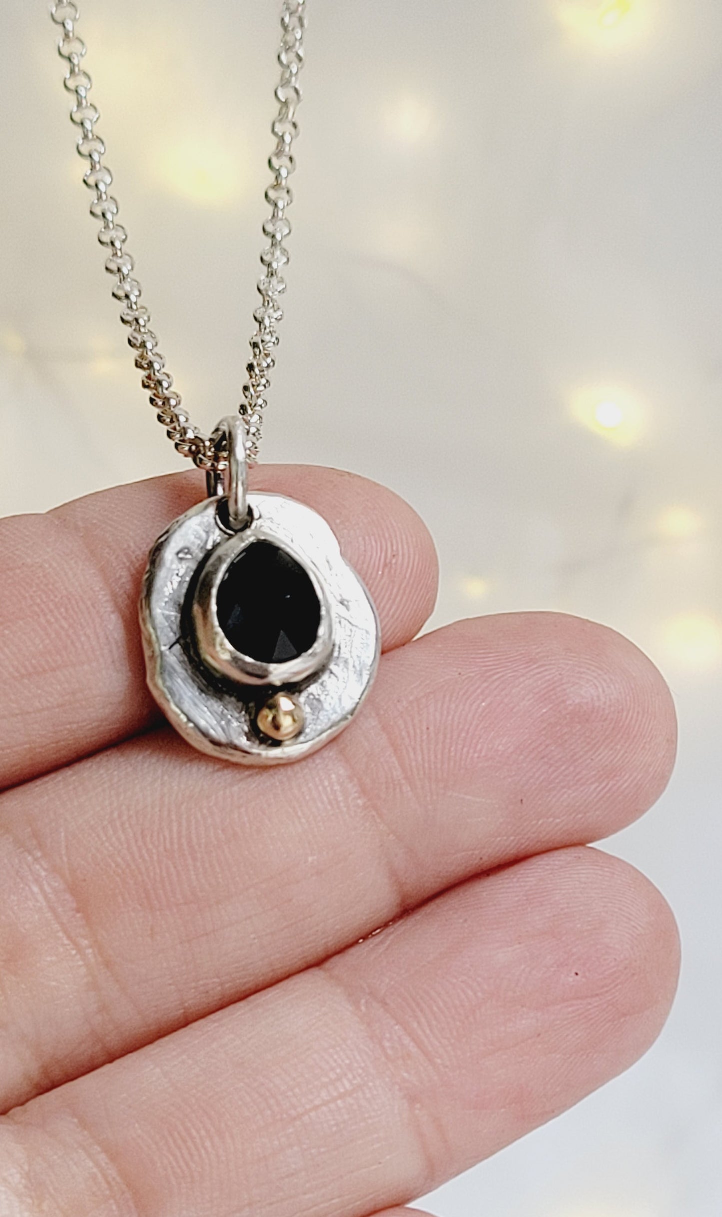 Handmade pendant in sterling silver with 14k gold detail and faceted onyx set
