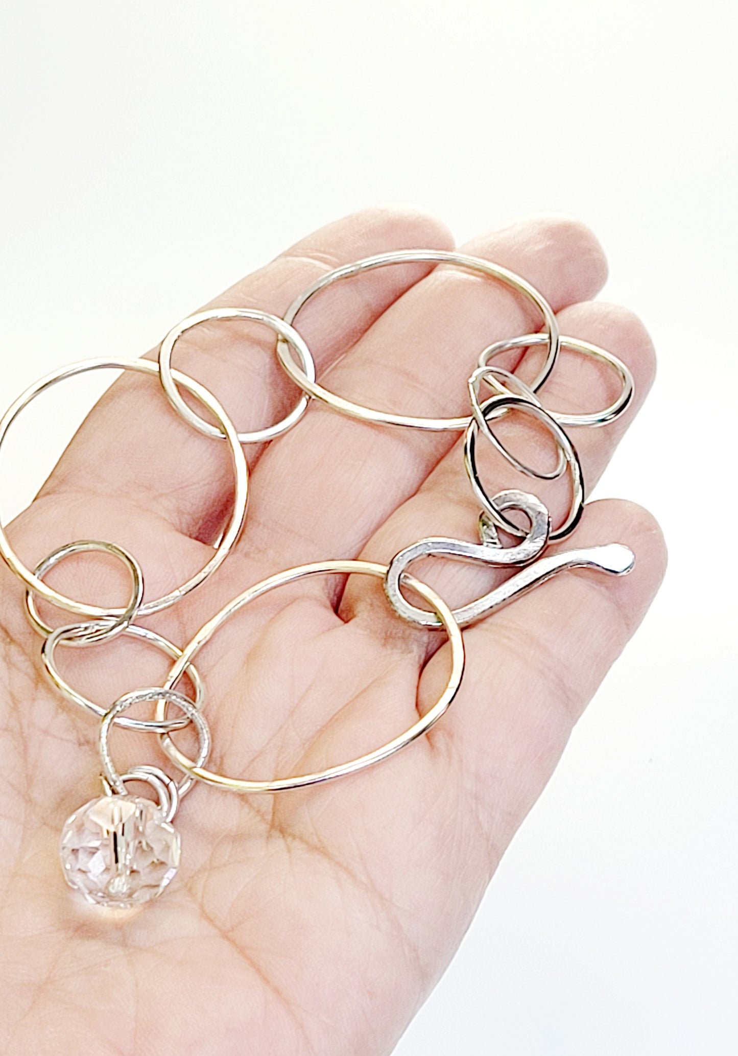 Sterling Silver bracelet features hammered rings.